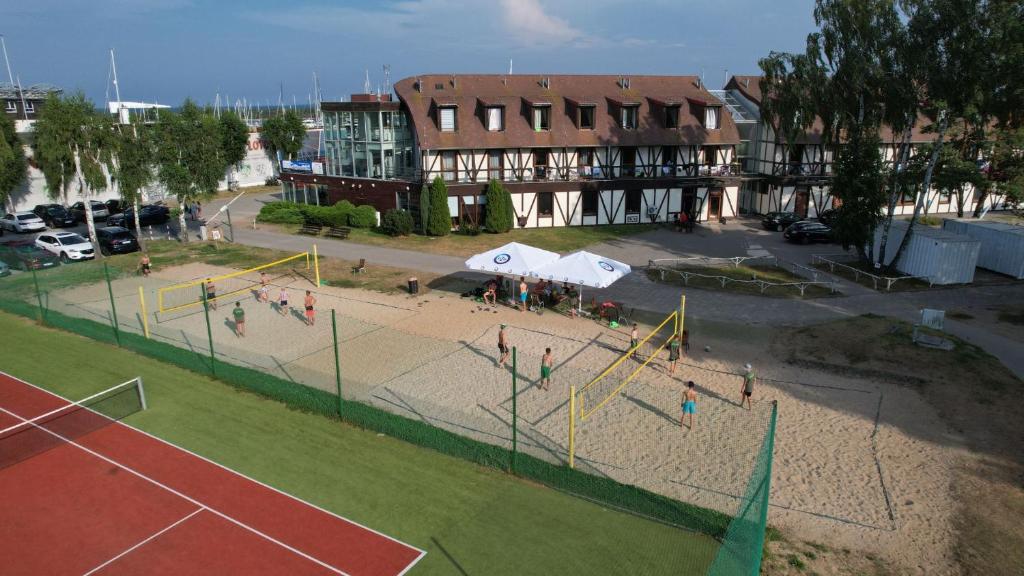 a tennis court with people playing on a court at Hotel Galion in Gdańsk