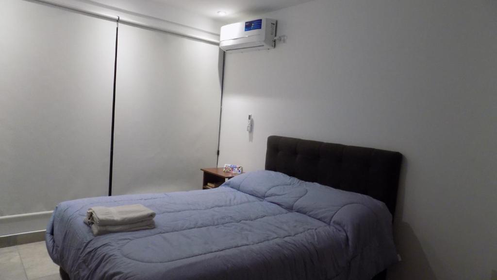 1 dormitorio con 1 cama con manta azul en Ananay en San Salvador de Jujuy