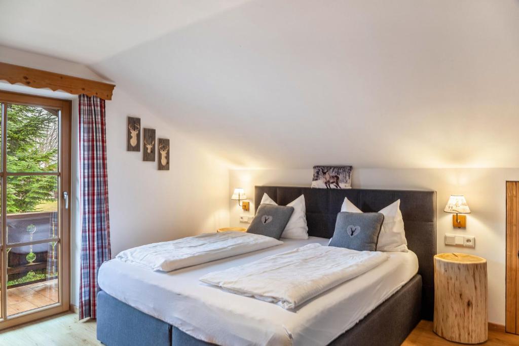 Un dormitorio con una cama grande y una ventana en Haus Alpenquelle Alpenblick, en Bad Kohlgrub