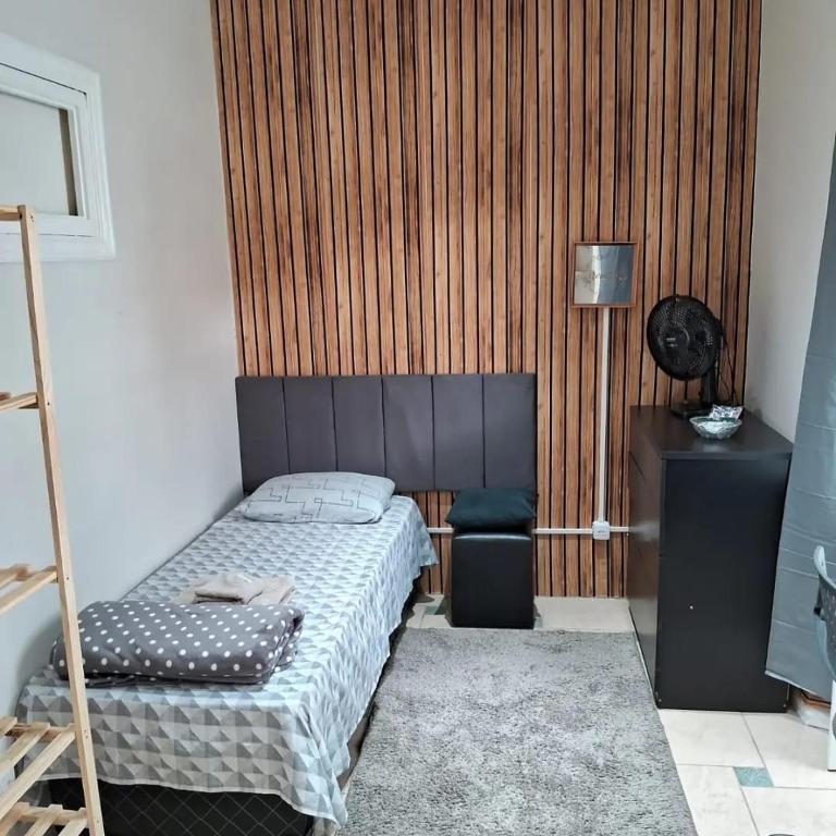 ein Schlafzimmer mit einem Bett, einem Tisch und einer Lampe in der Unterkunft dormitorio 01 privativo a 2 km de alphaville in Barueri