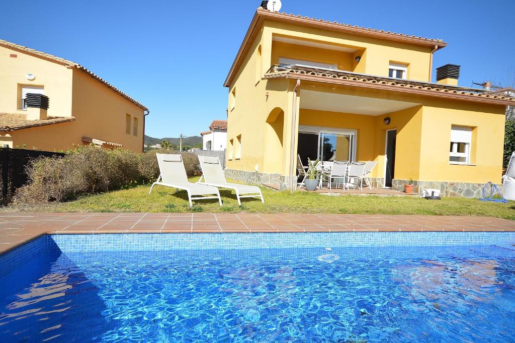 uma villa com piscina em frente a uma casa em Villa Naira em Calonge
