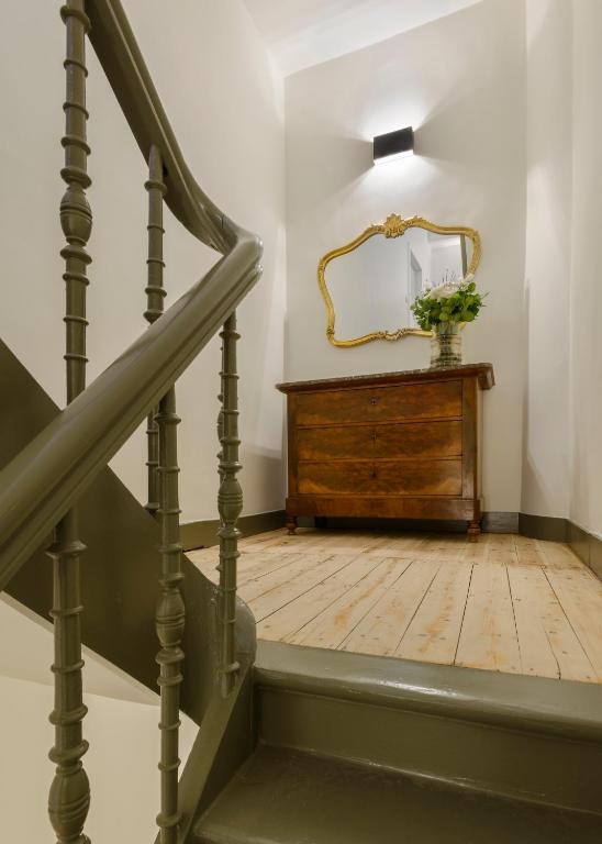 una scala con specchio e comò in legno di Our Bird's Nest in the Heart of Antwerp ad Anversa