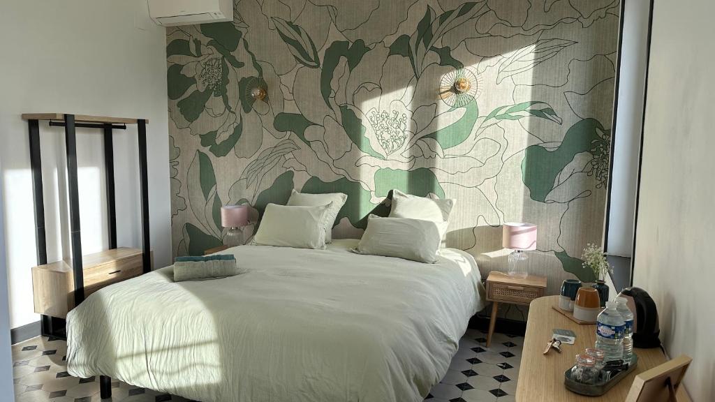 a bedroom with a white bed with a floral wallpaper at Chambre Pivoine au Domaine de l'Aven in Villeneuve-Minervois
