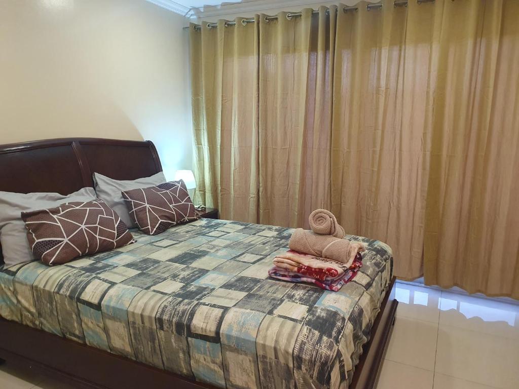 a bedroom with a bed with a blanket and pillows at Daichi Place Megatower Residences in Baguio