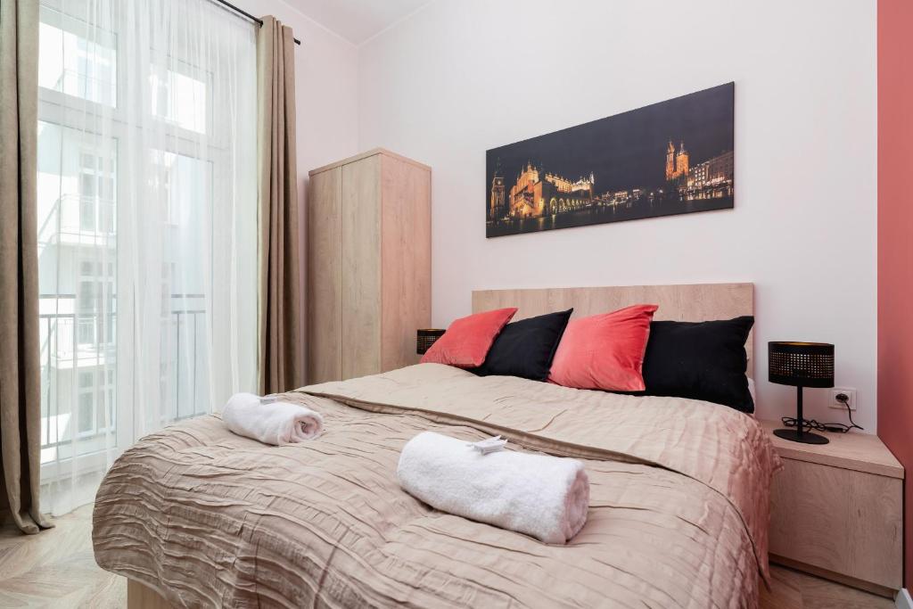 a bedroom with a large bed with two pillows on it at Starowiślna Studio Kazimierz Cracow by Renters in Krakow