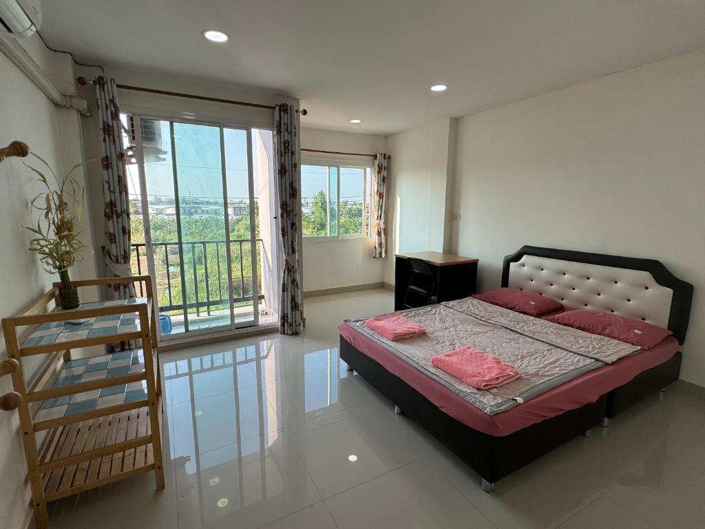 1 dormitorio con 1 cama y balcón en Boom inn en Nonthaburi
