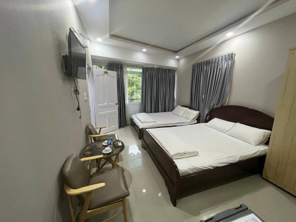 a small room with two beds and a window at Côn Đảo Xanh Hotel in Con Dao