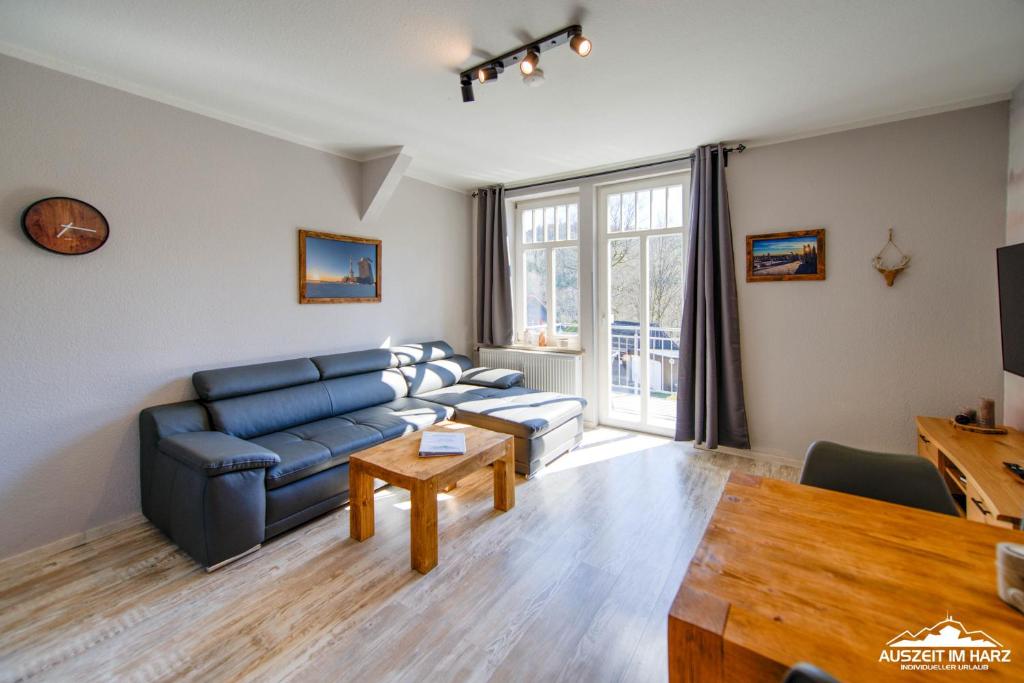 a living room with a blue couch and a table at Auszeit im Harz Haus 1 Wohnung Feuerstein in Schierke