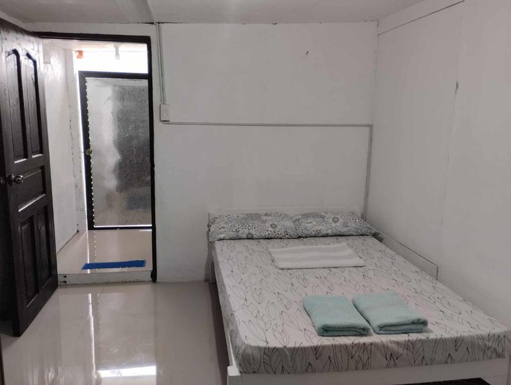 a small room with a bed with two pillows on it at Vin's Place Rentals - Studio Unit in Tagum