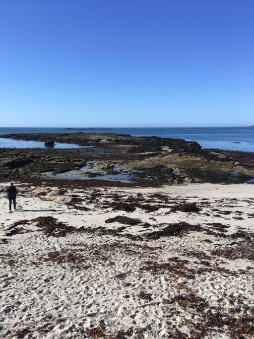 une personne debout sur une plage près de l'océan dans l'établissement Le Récif, maison indépendante Corniche de la mer, à Concarneau
