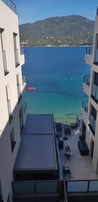 - une vue sur l'océan depuis deux bâtiments dans l'établissement MAGNIFIQUE APPARTEMENT LES PIEDS DANS L'EAU PROPRIANO, à Propriano