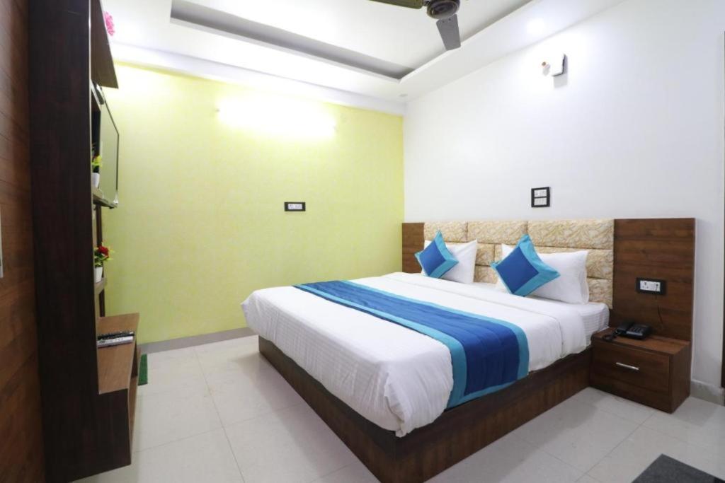 Schlafzimmer mit einem großen Bett mit blauer und weißer Bettwäsche in der Unterkunft HOTEL CRORE GRAND BHARAT STAY in Neu-Delhi