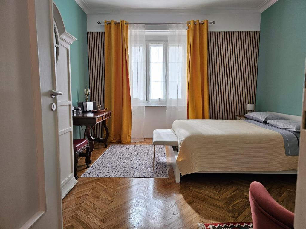 a bedroom with a bed and a window with orange curtains at Casa Torino Liberty in Turin