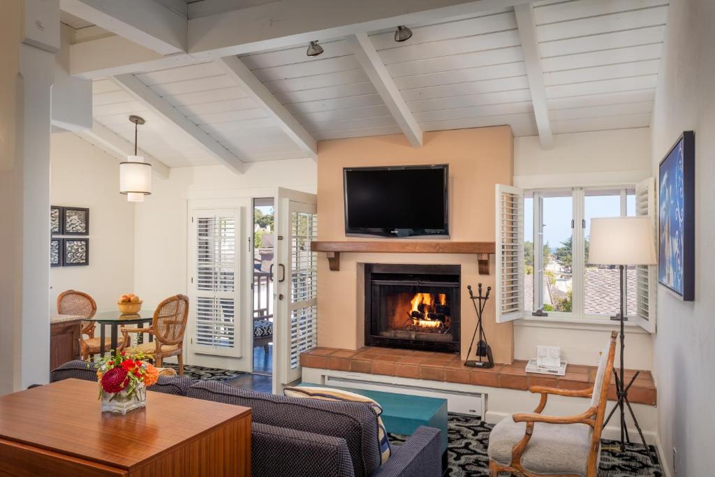 a living room with a fireplace and a tv at Hotel Pacific in Monterey