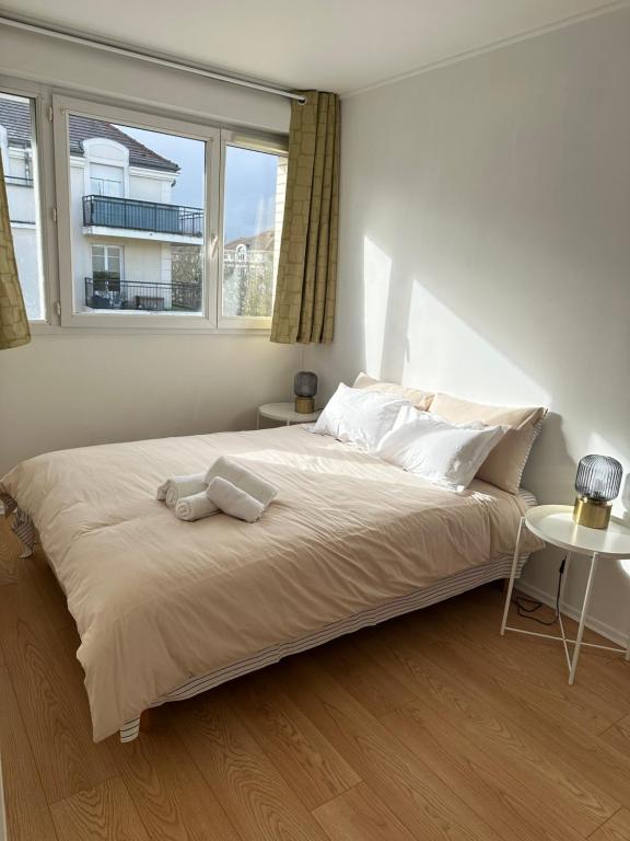 a bedroom with a large bed with a window at Jade Apart Bussy Centre Disney 10min in Bussy-Saint-Georges