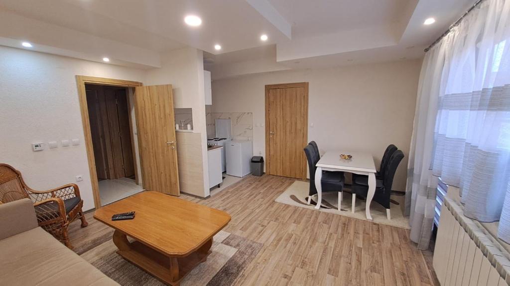 ein Wohnzimmer mit einem Sofa und einem Tisch in der Unterkunft Apartman Zirojević in Lukavica
