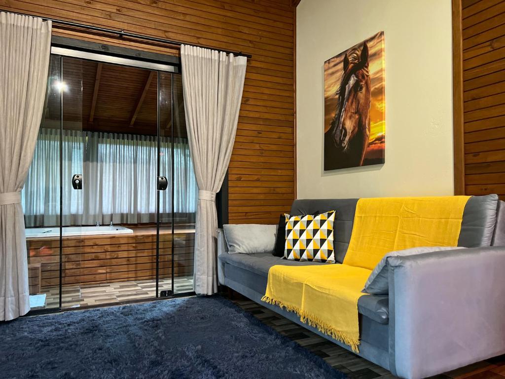 ein Wohnzimmer mit einem Sofa und einem Fenster in der Unterkunft Morada da Paz in Aguas Mornas