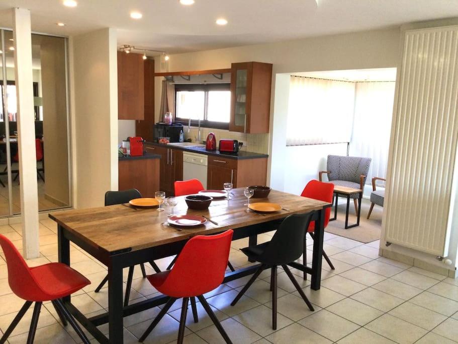a kitchen with a wooden table and red chairs at Appartement au Cœur de Ville : 6/8 personnes in Briançon
