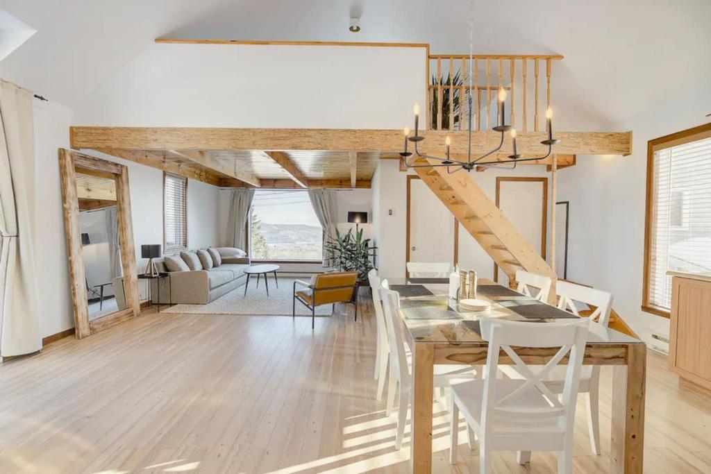 uma sala de jantar e sala de estar com mesa e cadeiras em Intimate Apartment with Scenic Views em Baie-Saint-Paul