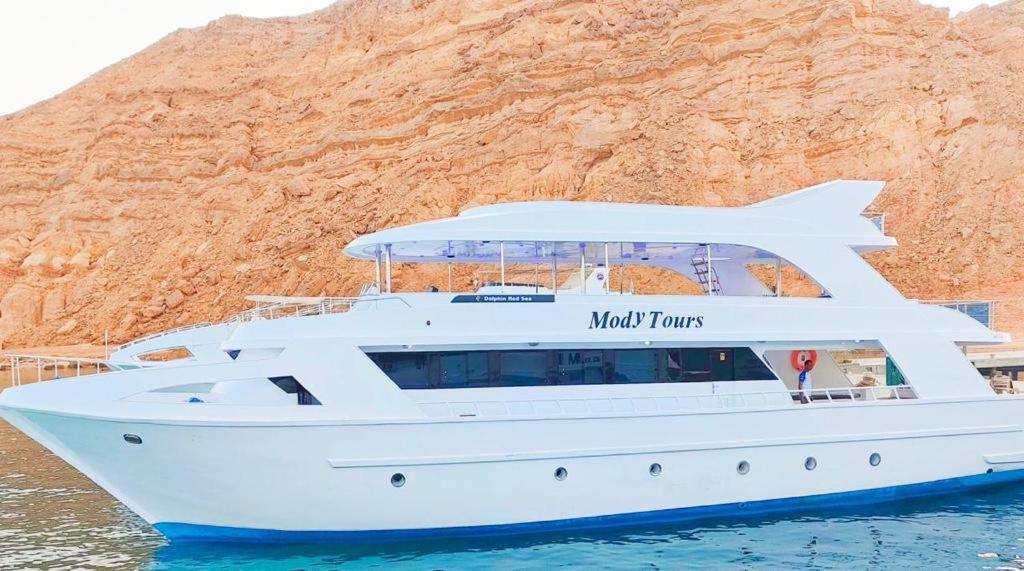 a white yacht in the water next to a mountain at VIP Yacht Daily RENT in Sharm El Sheikh