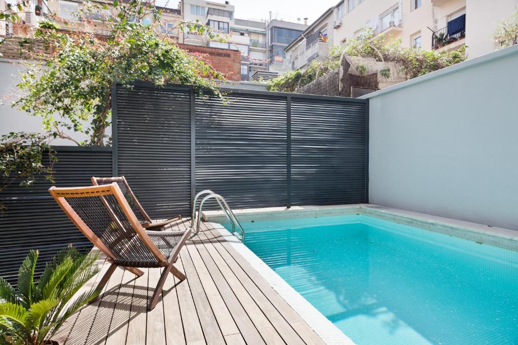 una silla sentada en una terraza junto a una piscina en Barcino Inversions - Modern Duplex with Private Garden and Swimming Pool, en Barcelona