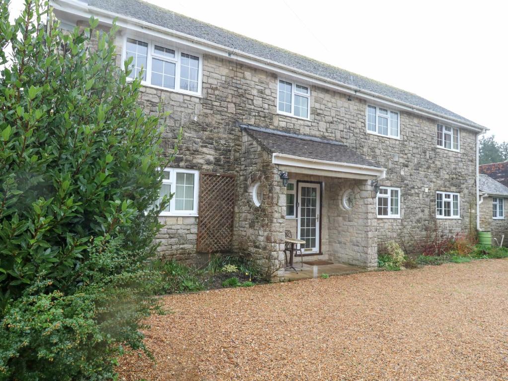 an old stone house with a driveway in front of it at Glyde House in Dorchester