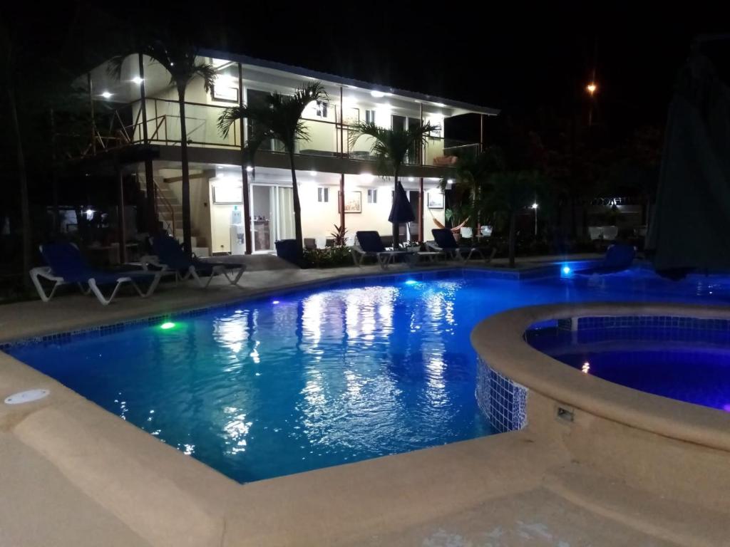 a swimming pool in front of a building at night at Malibu Dreams Village in Nueva Gorgona