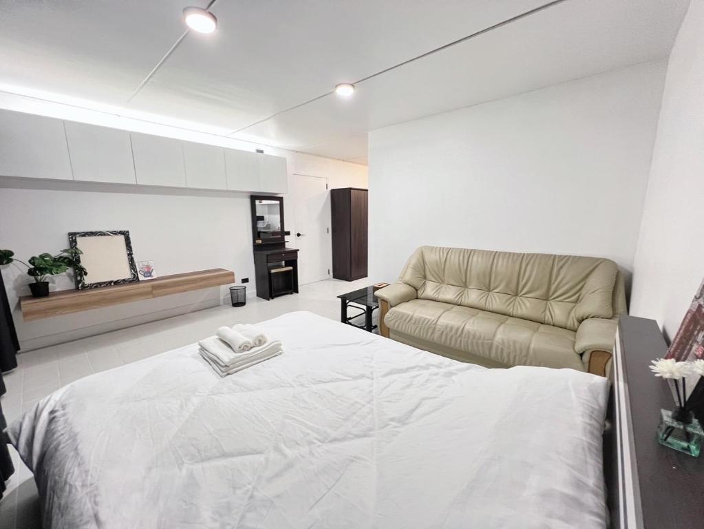 um quarto com uma cama e um sofá em Impact-Don Mueang Bangkok Popular Condo C4 em Pak Kret