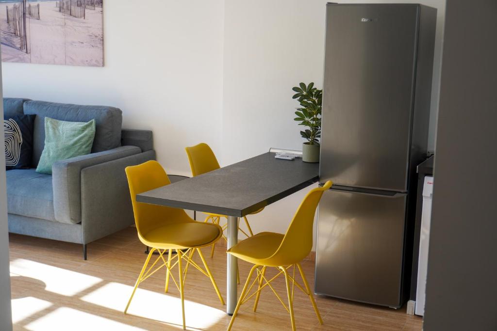 a kitchen with a table and yellow chairs at Holiday House Blue Sky La Gomera in San Sebastián de la Gomera