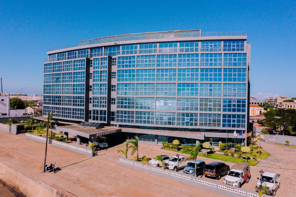 um grande edifício de vidro com carros estacionados em frente em Beira Terrace Hotel na Beira