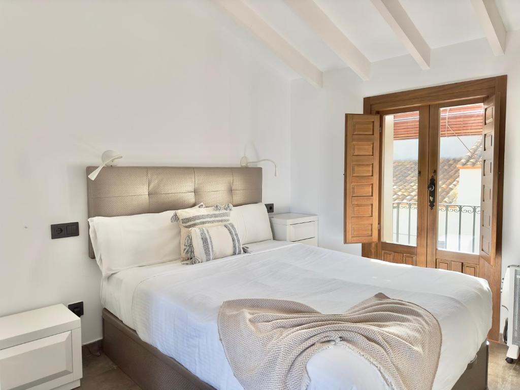 - une chambre blanche avec un grand lit et une fenêtre dans l'établissement La Buhardilla, à Altea