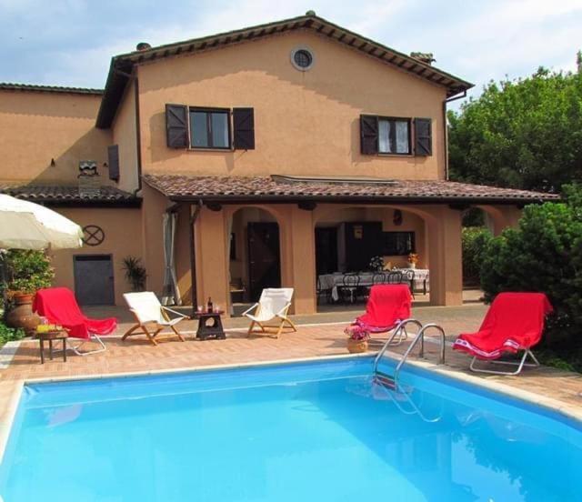 a house with a swimming pool in front of a house at IL PAGO in Calvi dellʼ Umbria