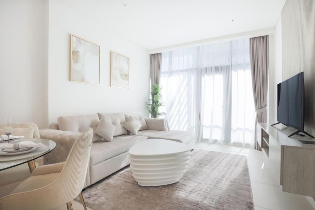 a white living room with a couch and a table at Modern 1 bedroom at Palm Jumeirah in Dubai