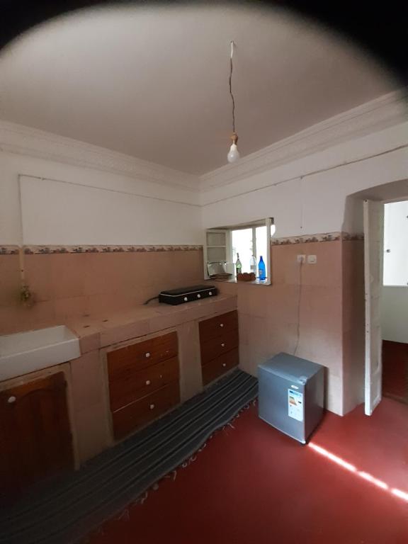 an empty kitchen with a counter and a window at Dar Sahara Ouarzazate in Ouarzazate