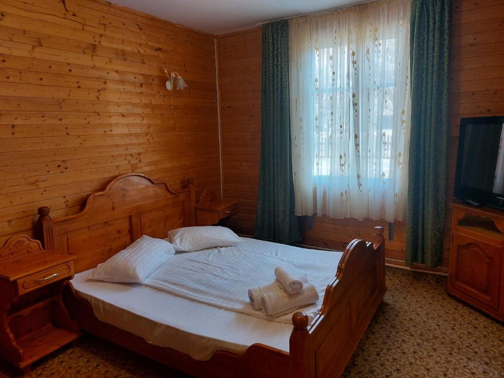 1 dormitorio con 1 cama con toallas en Complex Țurcana Transalpina, en Şugag