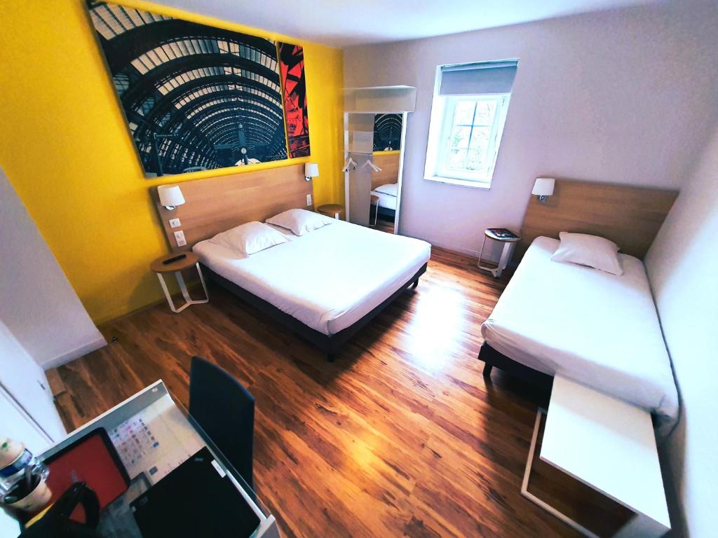 um quarto com duas camas e um computador portátil em Hôtel de la Gare - Restaurant Bistro Quai em La Roche-sur-Yon