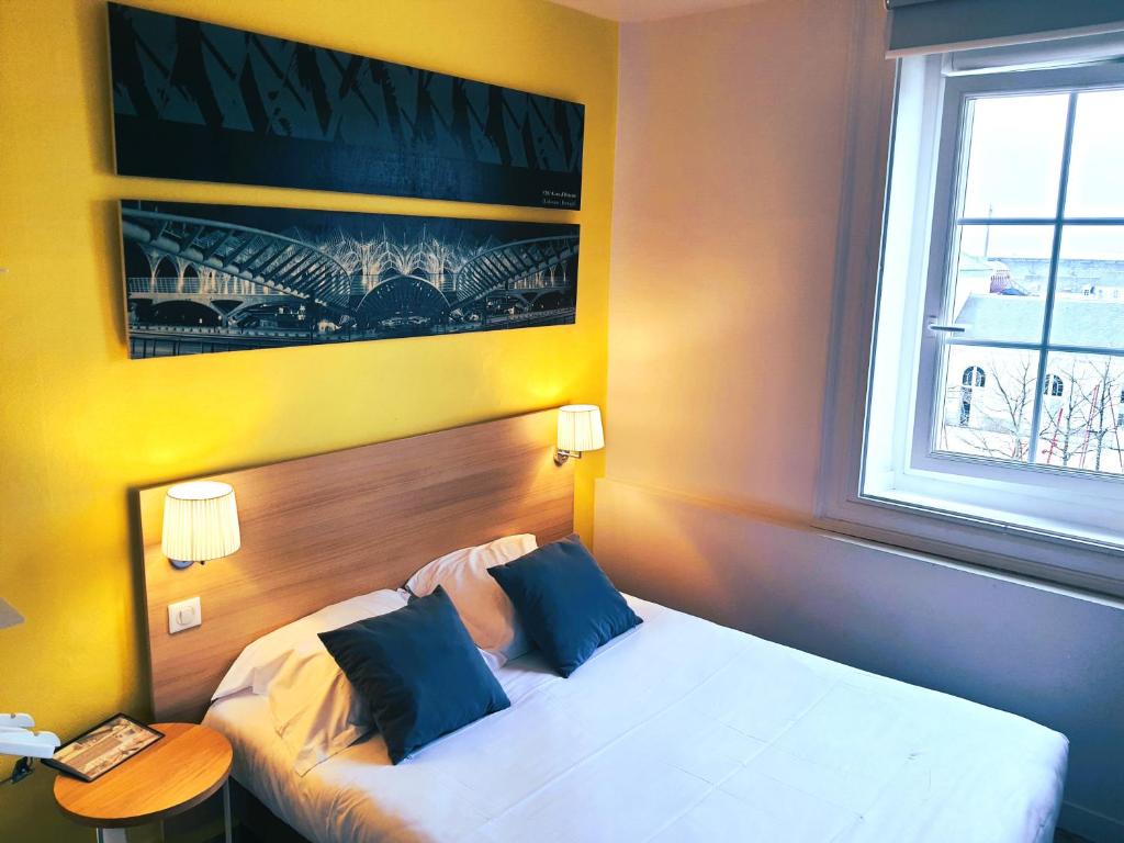 a hotel room with a bed and a window at Hôtel de la Gare - Restaurant Bistro Quai in La Roche-sur-Yon