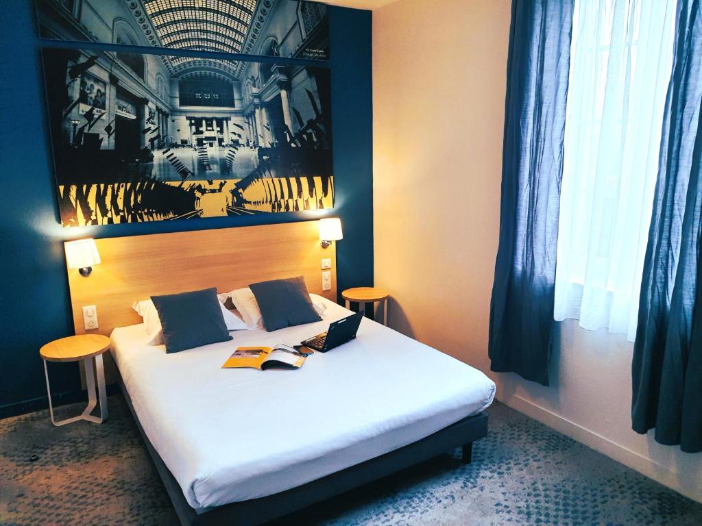 a bedroom with a white bed with two tables at Hôtel de la Gare - Restaurant Bistro Quai in La Roche-sur-Yon