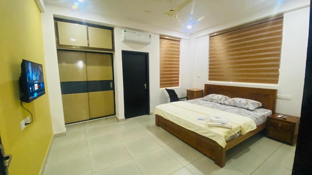 um quarto com uma cama e uma televisão em Phoenix Residency, Near MVR Cancer Centre, Vellalassery, NIT, Calicut em Māvūr
