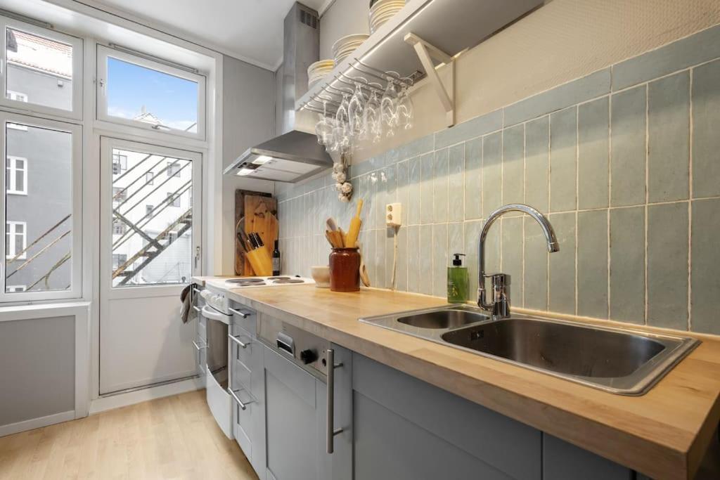une cuisine avec un évier et une grande fenêtre dans l'établissement New Spacious & Cozy Hideaway with Central Location, à Bergen