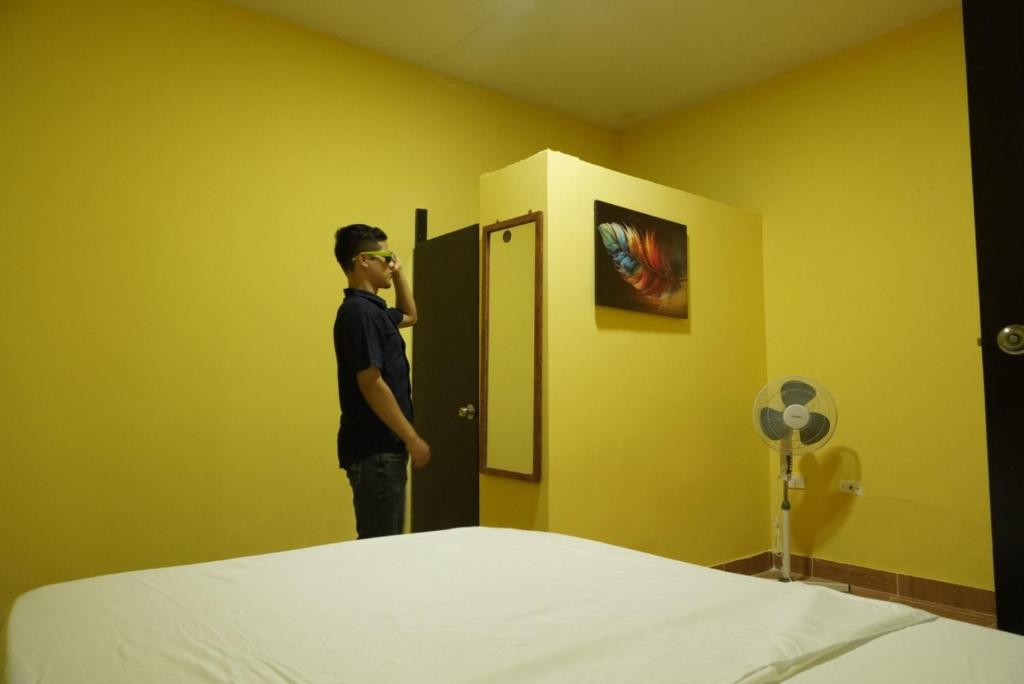 a man talking on a phone in a room with a bed at Casa habitacion, 4 dormitorios in Tarapoto