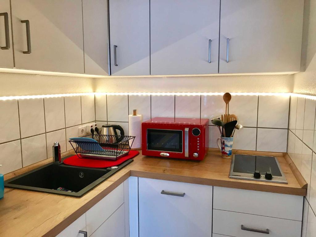 una cocina con microondas rojo en una encimera en Ferienwohnung Leuchtturm 21, en Schausende