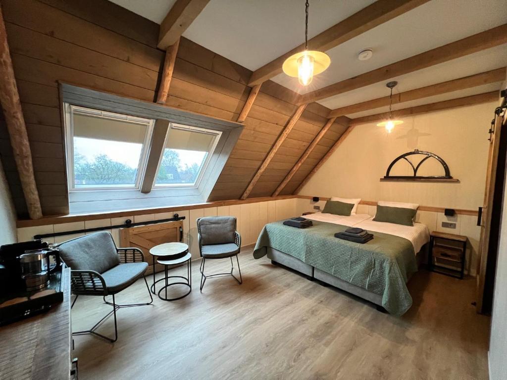 um quarto com uma cama, uma mesa e cadeiras em B&B Eindeloos em Opeinde
