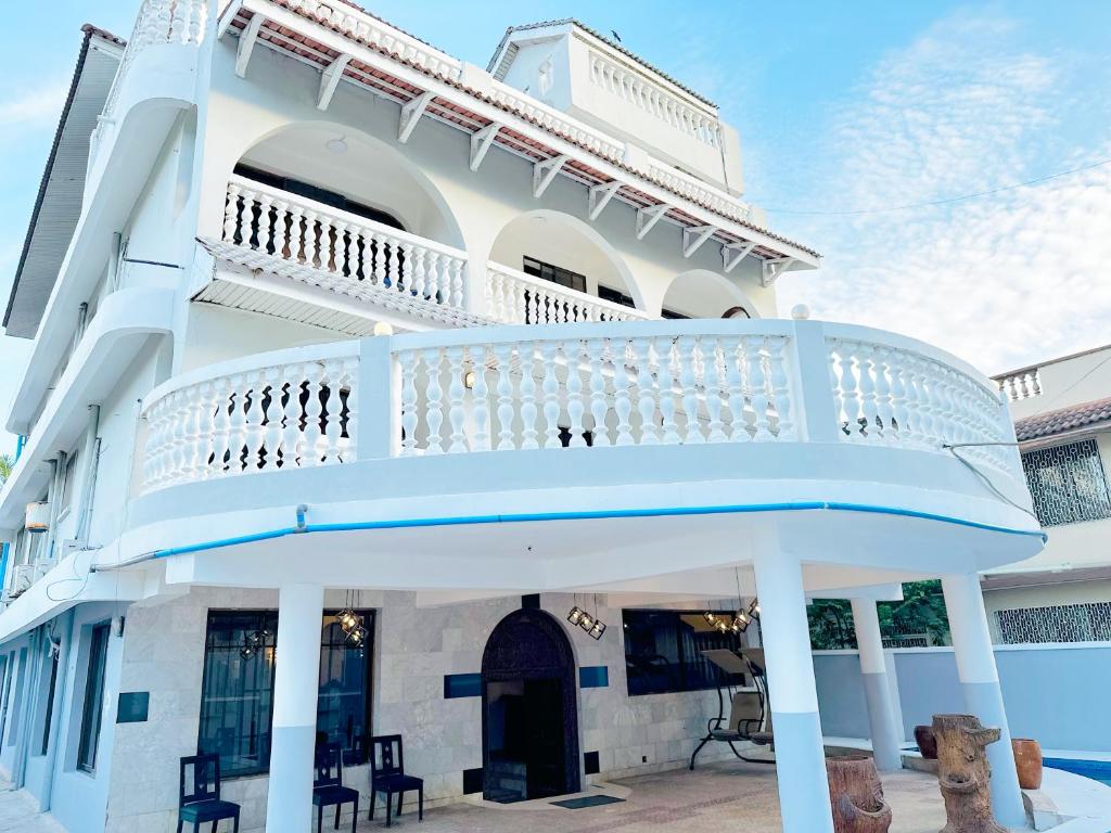 um grande edifício branco com uma varanda branca em Nile Hotel em Dar es Salaam