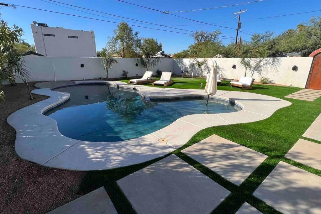 una piscina en un patio con sillas y césped en Sam Hughes Desert Oasis, Private Pool & Walk to UA, en Tucson
