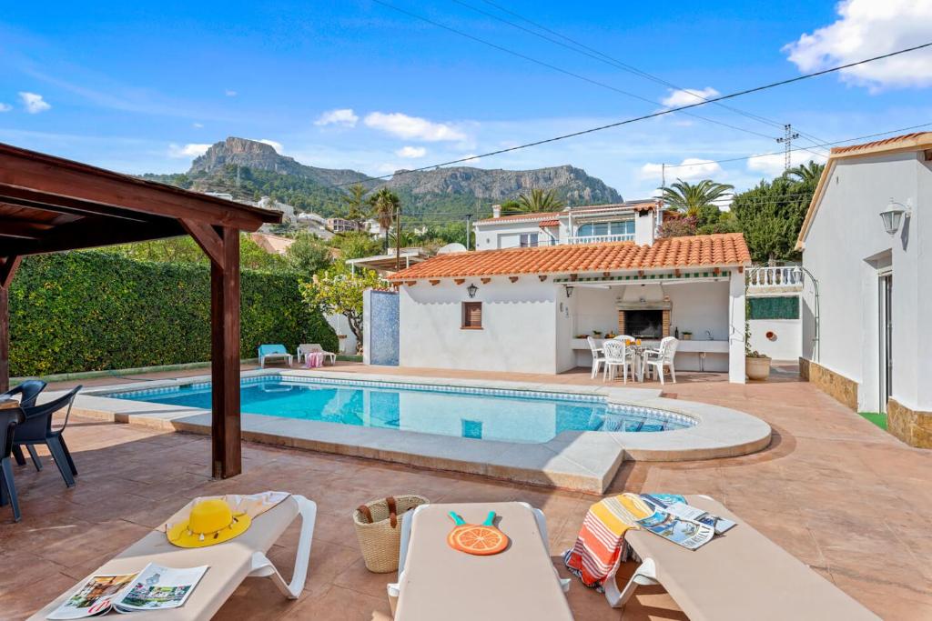 a villa with a swimming pool and a house at Villa Mercedes - Plusholidays in Calpe