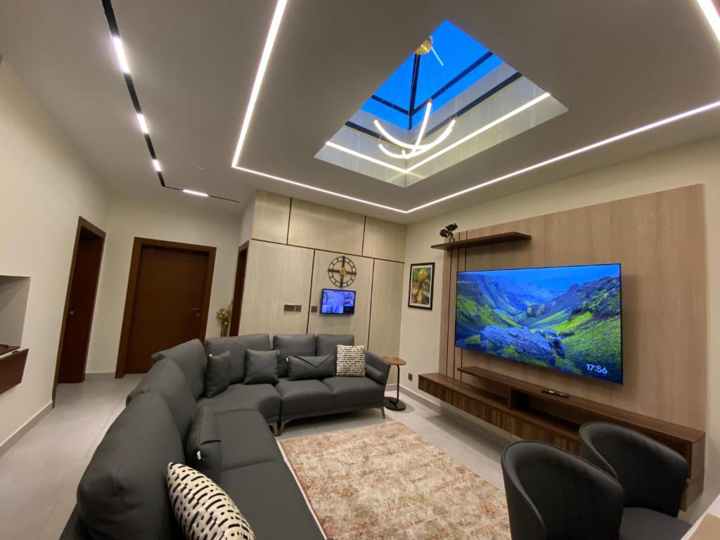 sala de estar con sofá y TV de pantalla plana en Firefly Retreat-your home away from home, en Rawalpindi