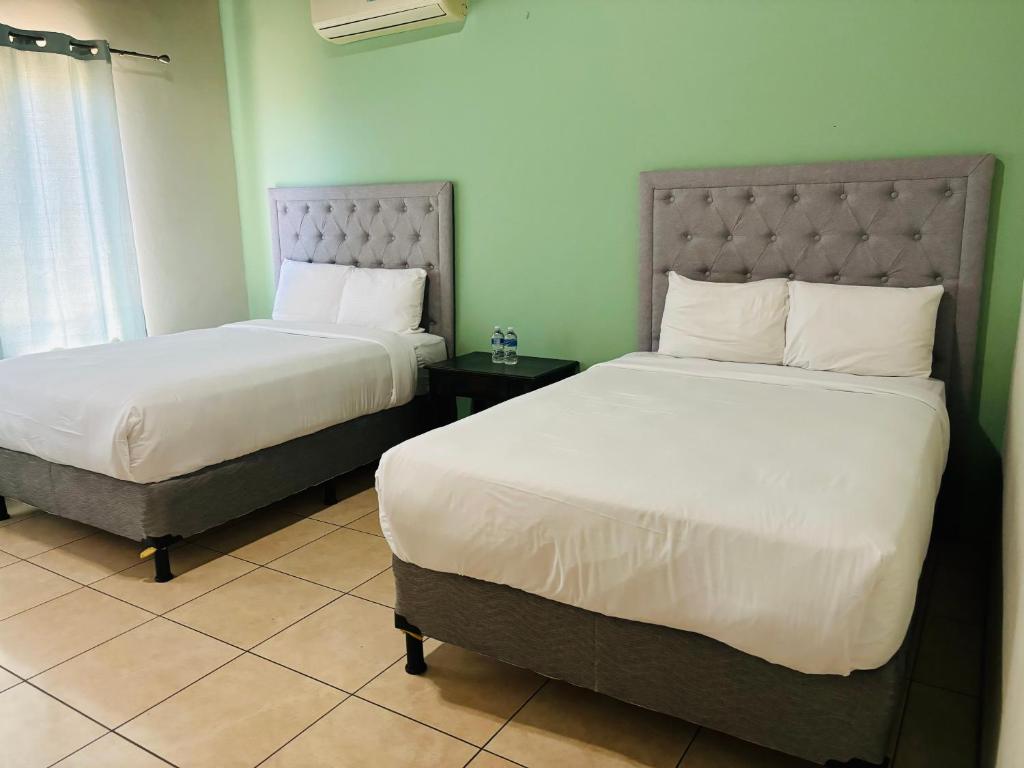 汕埠的住宿－Casa Primavera SPS，一间卧室设有两张床和窗户。