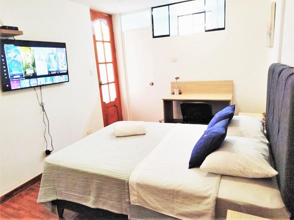 una camera da letto con un letto e una TV a parete di Hermosa Habitación c/ Baño privado - Huacachina. a Ica
