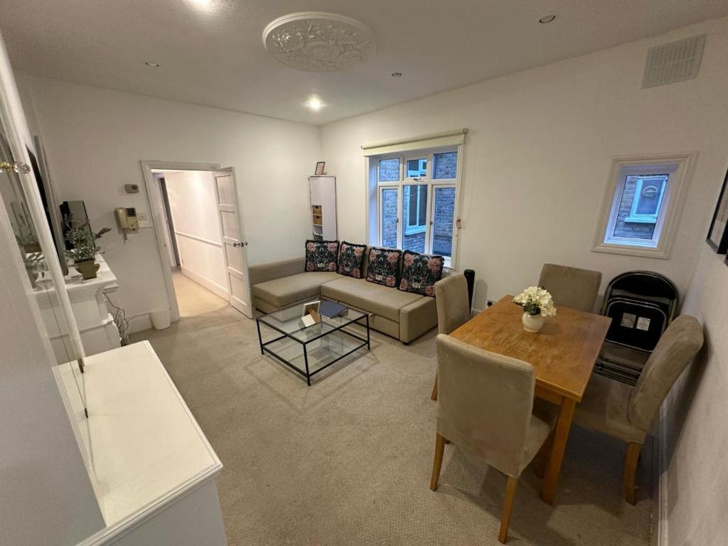 a living room with a table and a couch at Lovely 3 bedroom maisonette with private roof terrace in Hammersmith in London